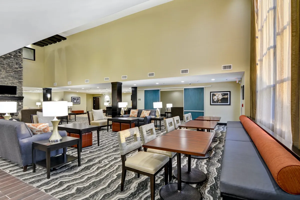 A spacious interior with multiple comfortable seating options, stylish tables, decorative lighting, and large windows that let in natural light. The environment is relaxed and inviting, providing a perfect spot for morning coffee, reading, or winding down after a day out.